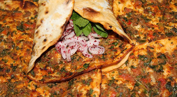 In Deutschland wird Lahmacun häufig mit Fleisch, Gemüse und Soße serviert In Deutschland wird Lahmacun häufig mit Fleisch, Gemüse und Soße serviert